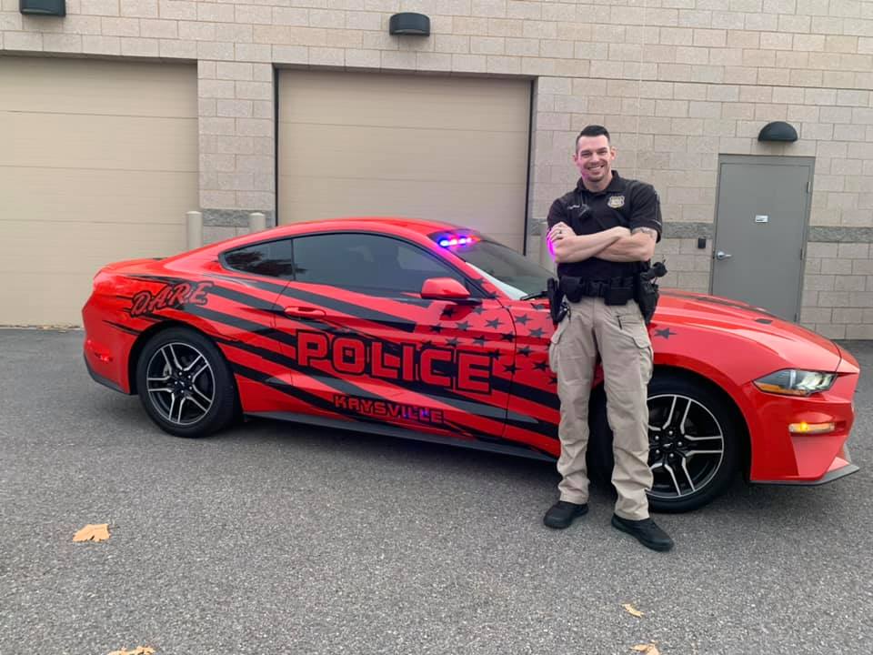Officer Stanford in front of DARE car